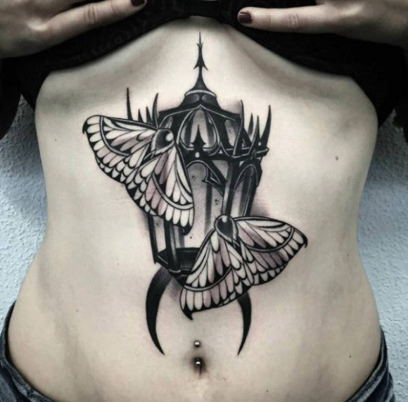 Moths to a lantern sternum tattoo