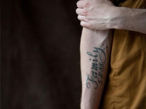 Man met tekst "familie" op zijn arm getatoeëerd